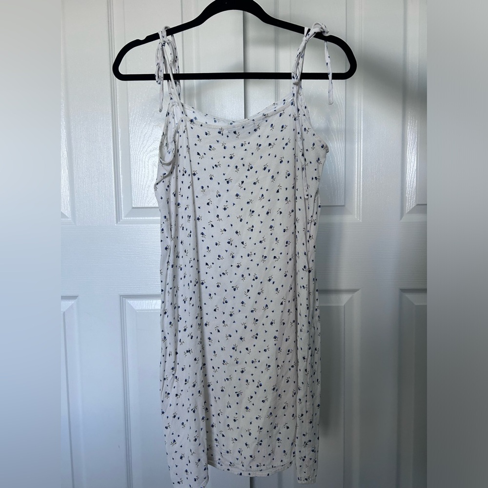 This white brandy melville dress is one size with blue flower detailing